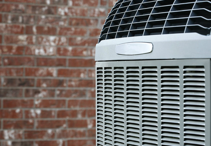 hvac installation closeup of light gray hvac unit with brick wall in background hudson fl